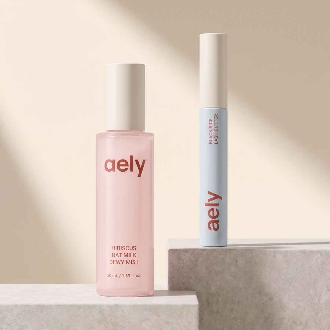 The Calm and Curl Duo: the Hibiscus Oat Milk Dewy Mist beside the Black Rice Lash Butter, both named on the packaging