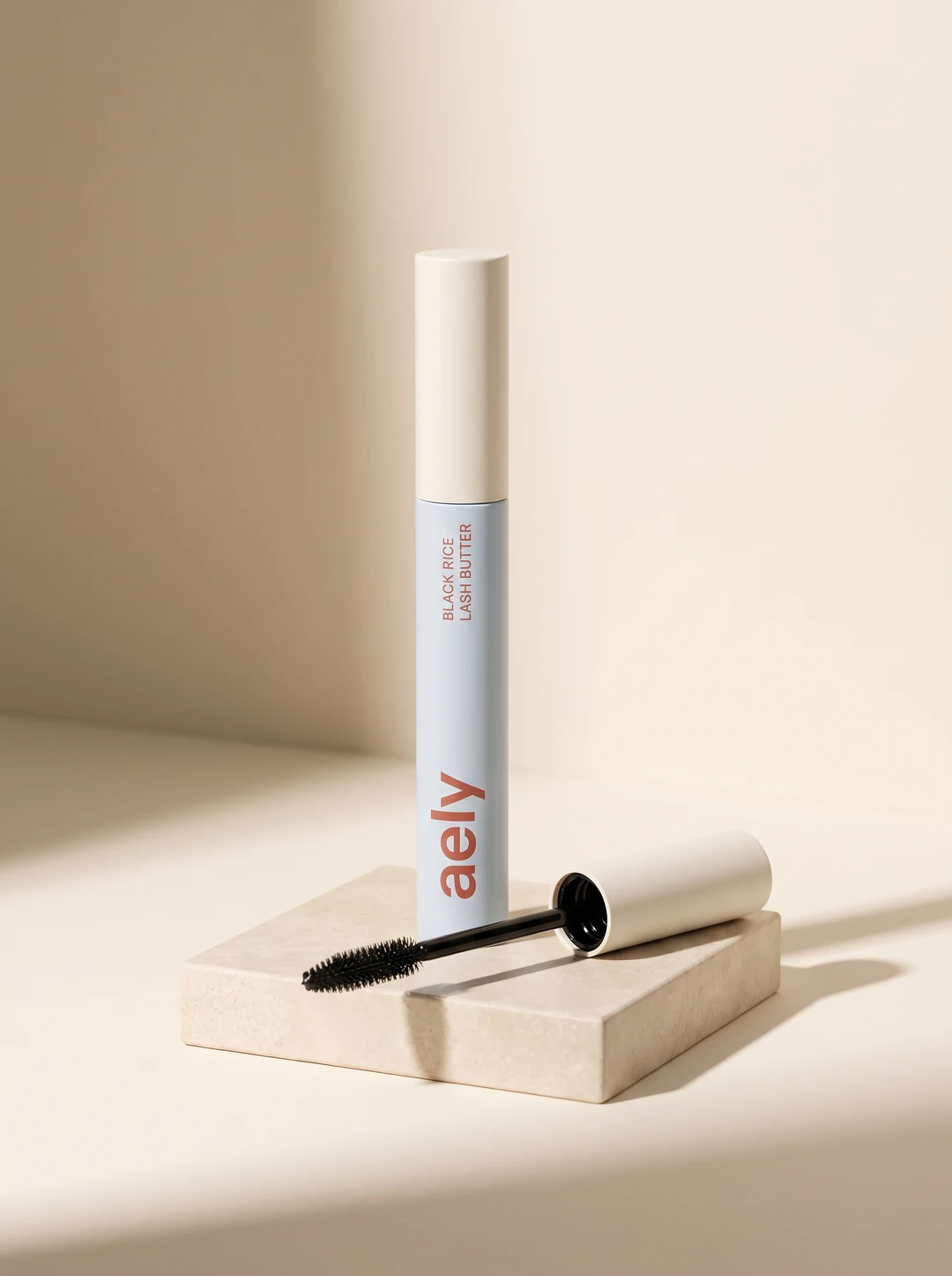 Black Rice Lash Butter, a powder-blue tube with a cream cap and its wand beside it, the name printed up the tube
