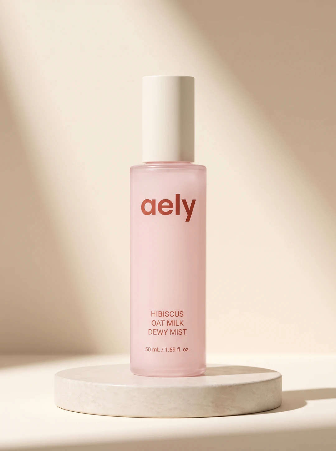Hibiscus Oat Milk Dewy Mist, a blush-pink glass bottle with a cream cap, the name printed on the glass